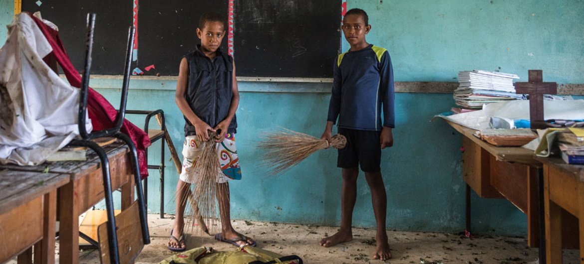 Filise, de 10 años, y Eremodo (der.), de 12, inspeccionan lo que ha quedado de su escuela en la isla de Vuaki después del paso del ciclón Winston. Foto: UNICEF/Sokhin