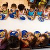 Niños comiendo en su colegio dentro de un programa escolar en América Latina.