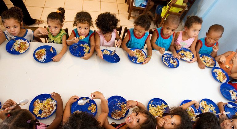 Niños comiendo en su colegio dentro de un programa escolar en América Latina.