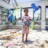 A seven-year old girl stands in the destroyed library of Nabau District School in Ra Province, Fiji.