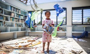 A seven-year old girl stands in the destroyed library of Nabau District School in Ra Province, Fiji.