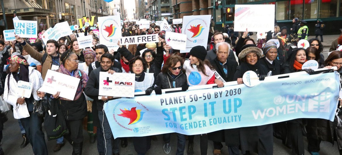 Des femmes et des hommes manifestant pour l'égalité entre les hommes et les femmes. Photo ONU femmes/Ryan Brown