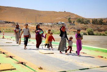 Des enfants et des femmes yézidis ayant fui la montagne de Sinjar reviennent en Iraq de Syrie via un poste frontière dans la ville de Peshkhabour, dans le gouvernorat de Dohuk.