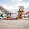 Ground crew members are loading cargo onto an Emirates airplane at an airport.