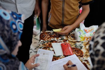 Les familles déplacées à Kirkouk, en Iraq, remplissent des formulaires avant de pouvoir bénéficier de kits humanitaires fournis par l'UNICEF et le PAM. Photo : UNICEF / Lindsay Mackenzie