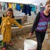 在黎巴嫩的叙利亚难民儿童正在用水桶取水。儿基会图片/Shehzad Noorani