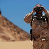 Un officer de liaison militaire de la Mission des Nations Unies pour l'organisation d'un référendum au Sahara occidental (MINURSO), observe au travers de ses jumelles lors d'une patrouille de surveillance du cessez-le-feu à Oum Dreyga, au Sahara occidental (juin 2010)