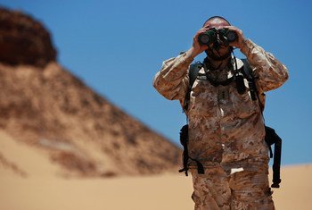 Un officer de liaison militaire de la Mission des Nations Unies pour l'organisation d'un référendum au Sahara occidental (MINURSO), observe au travers de ses jumelles lors d'une patrouille de surveillance du cessez-le-feu à Oum Dreyga, au Sahara occidental (juin 2010).  Photo ONU /Martine Perret