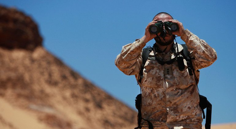 A Military Liaison Officer of the UN Mission for the Referendum in Western Sahara (MINURSO), looks through binoculars during a ceasefire monitoring patrol in Oum Dreyga, Western Sahara (June 2010). 