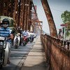 Une file de motos traverse le pont Long Bien sur la rivière Rouge à Hanoi, au Viet Nam. La moitié de la population mondiale vit en milieu urbain. 