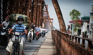 Une file de motos traverse le pont Long Bien sur la rivière Rouge à Hanoi, au Viet Nam. La moitié de la population mondiale vit en milieu urbain. 