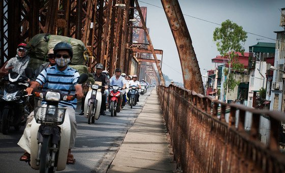 An array of motorbikes cross Long Bien Bridge on the Red River in Hanoi, Viet Nam.