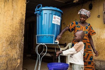 Una madre enseña a su hijo cómo lavarse correctamente las manos en el marco de un programa de prevención de enfermedades en Guinea Conakry. Foto: UNMEER/Martine Perret