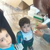 Сотрудники Агентства ООН оказывают помощь детям из семей палестинских беженцев в пригороде Дамаска, Сирия.   