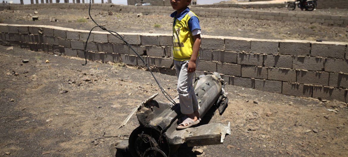 Boy playing on piece of exploded artillery shell which landed near his home, in the village of Al Mahjar, a suburb of Sana’a, Yemen.