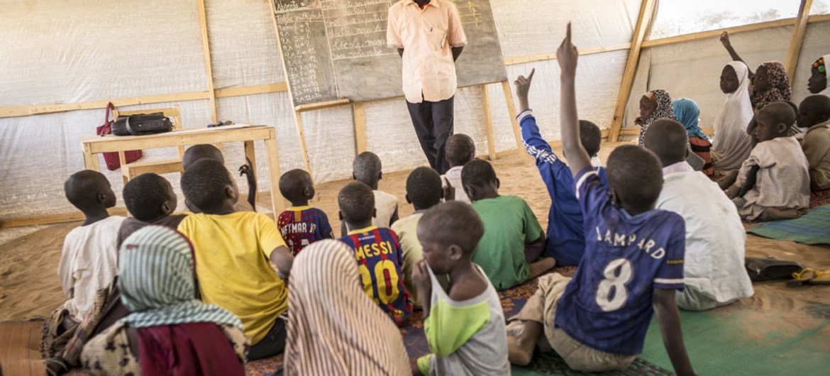 أطفال في مركز تعليم مؤقت في معسكر دار السلام، في منطقة بحيرة تشاد. ويقيم أكثر من 4900 لاجئ  نيجيري حاليا في المخيم، حيث أنشأت اليونيسف 16 أماكن مؤقتة للتعليم. المصدر: اليونيسف / الشرقاوي