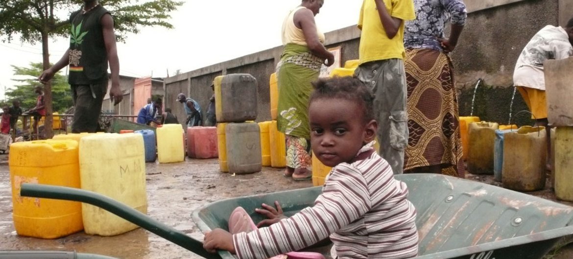 A child plays in a wheelbarrow while her family collects water into jerrycans in Brazzaville, the capital of the Republic of Congo.