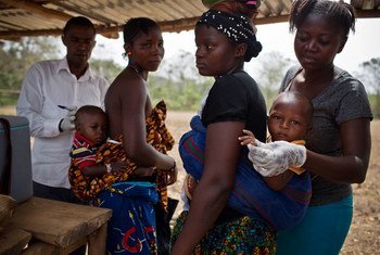Mothers bring their children to be vaccinated against polio at a market place vaccination point during a polio vaccination campaign in Tunkia, near Kenema in Sierra Leone.