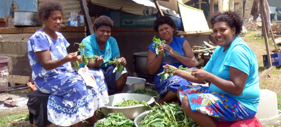 Mudu Village, Koro, Fiji, 2016: Vilisa Naivalubasaga, left, preparing donated food with a group of other women whose families have been left homeless by the cyclone on Koro.