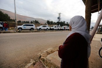 A woman in Wadi Barada, a town outside Madaya, Rural Damascus, watches a  convoy carrying aid supplies.