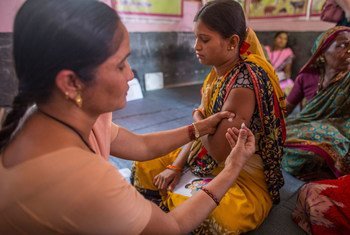 A health worker immunizes a pregnant woman inside at health center in Aurangabad, India.