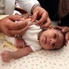 A nurse administers an immunization to a baby at a clinic in Ein Al Beidah, a village in northern West Bank.