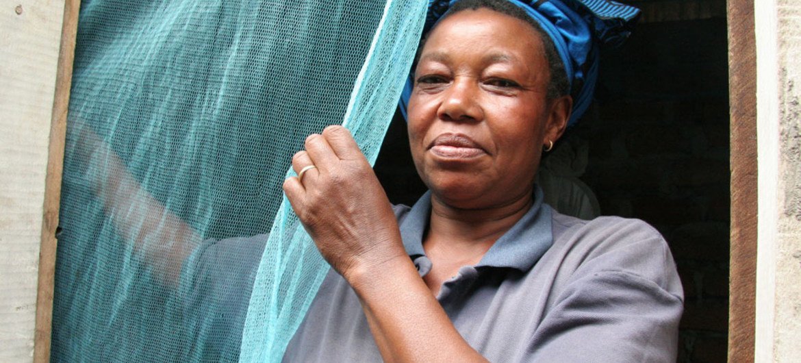 坦桑尼亚妇女挂起防疟疾蚊帐  世卫组织图片/S. Hollyman
