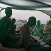 أم مع أطفالها تحت ناموسية في موقع توزيع الأغذية في حالات الطوارئ بادارة اليونيسف وبرنامج الأغذية العالمي في ولاية الوحدة بجنوب السودان. المصدر: اليونيسف / كيت هول