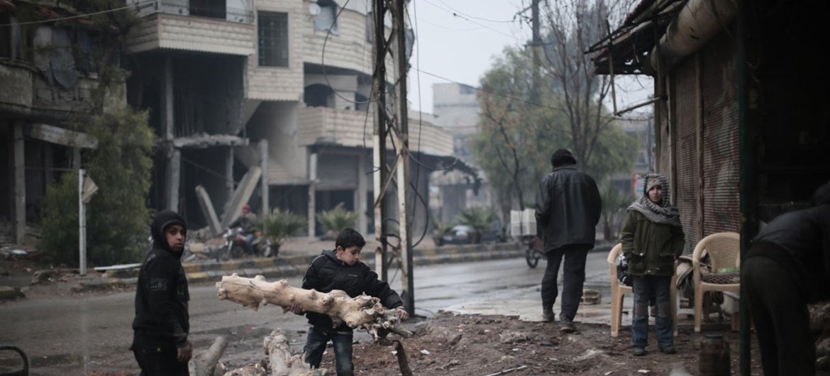 Deux enfants récupèrent des branches pour faire du feu dans le village de Kafar Batna, dans le Grand Damas, en Syrie.