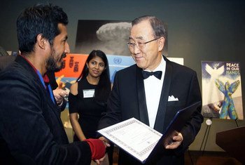 Secretary-General Ban Ki-moon  awards Ivan Ciro Palomino Huamani his first-prize certificate in the UN Poster for Peace contest.