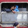 Папа целует  малыша в поезде  в  бывшей югославской Республике Македонии  в районе возе центра приема беженцев. Фото ЮНИСЕФ