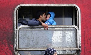 Un père embrasse son petit garçon dans un train près de la ville de Gevgelija, dans l'ancienne République yougoslave de Macédoine. Photo UNICEF/UN012729/Georgiev