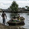 A family in Cap Haïtien, Haiti, loads supplies onto a boat during the flooding in 2014.