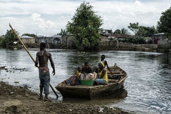 A family in Cap Haïtien, Haiti, loads supplies onto a boat during the flooding in 2014.