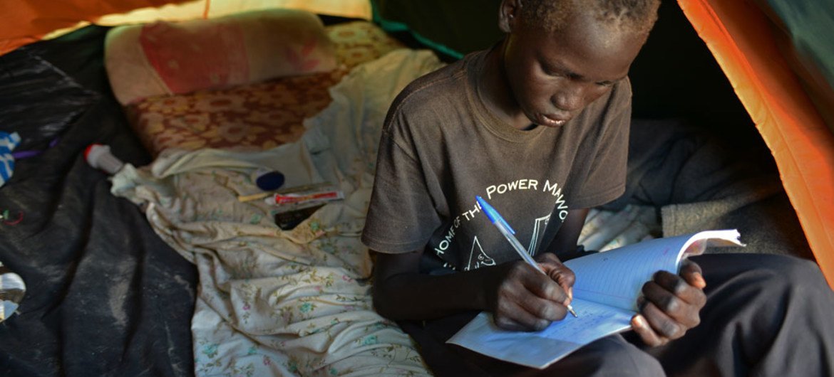 A young boy writes in his maths book in the Tomping Protection of Civilians site, on the base of the United Nations peacekeeping mission in South Sudan (UNMISS) in Juba, the capital.