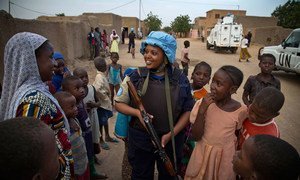 Un oficial de policía rwandés, que prestó servicios en la misión de paz de la ONU en Malí, habla con la población local durante una patrulla en la ciudad norteña de Gao en mayo de 2014.