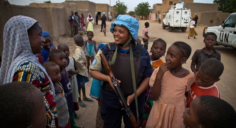 A Rwandan police officer serving with the UN peacekeeping mission in Mali (MINUSMA) speaks to the local population during a patrol in the northern town of Gao in May 2014.