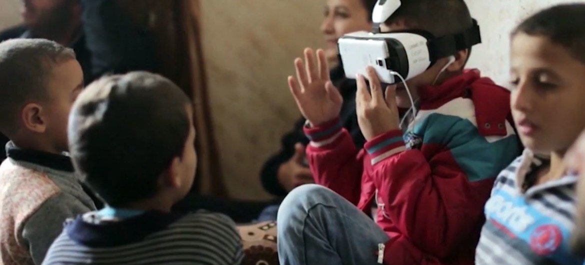 Children watching a virtual reality film in a refugee camp. Screen shot from UNTV 21st Century's Virtual Reality: Creating Humanitarian Empathy