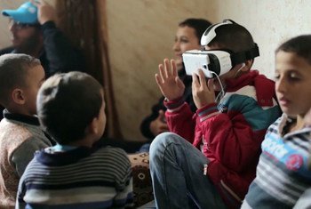 Children watching a virtual reality film in a refugee camp. Screen shot from UNTV 21st Century's Virtual Reality: Creating Humanitarian Empathy