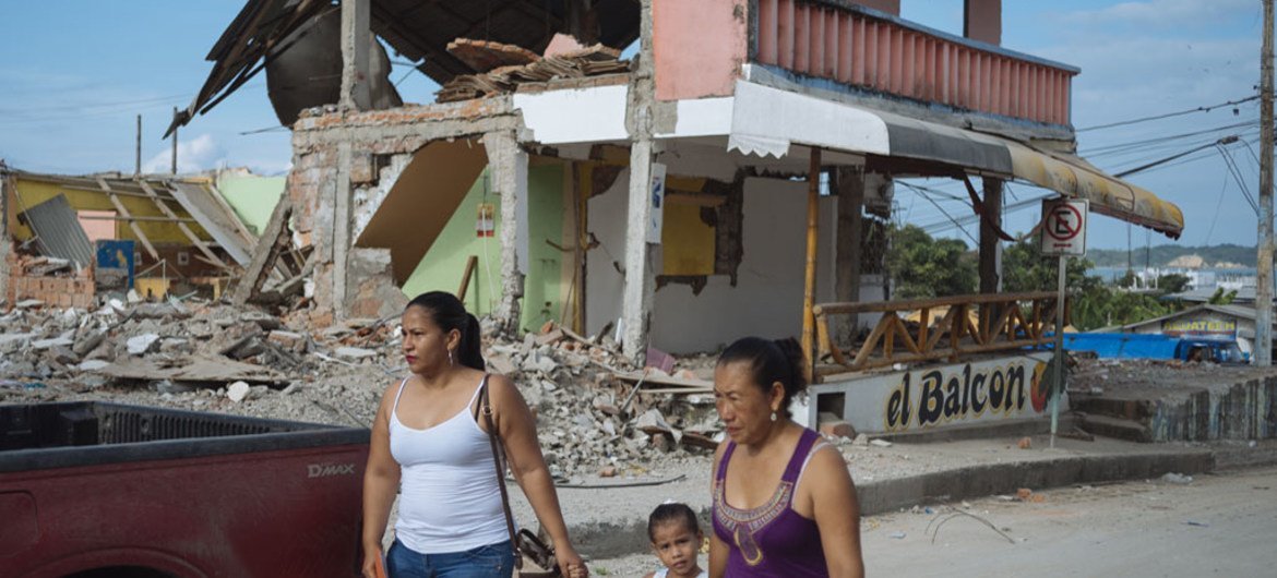 On 5 May 2016, two women and a young girl walk past a building destroyed by the earthquake in Nuevo Pedernales, Manabi, Ecuador.