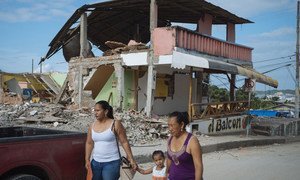 On 5 May 2016, two women and a young girl walk past a building destroyed by the earthquake in Nuevo Pedernales, Manabi, Ecuador.