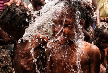 Гаитянские дети охлаждаются  водой