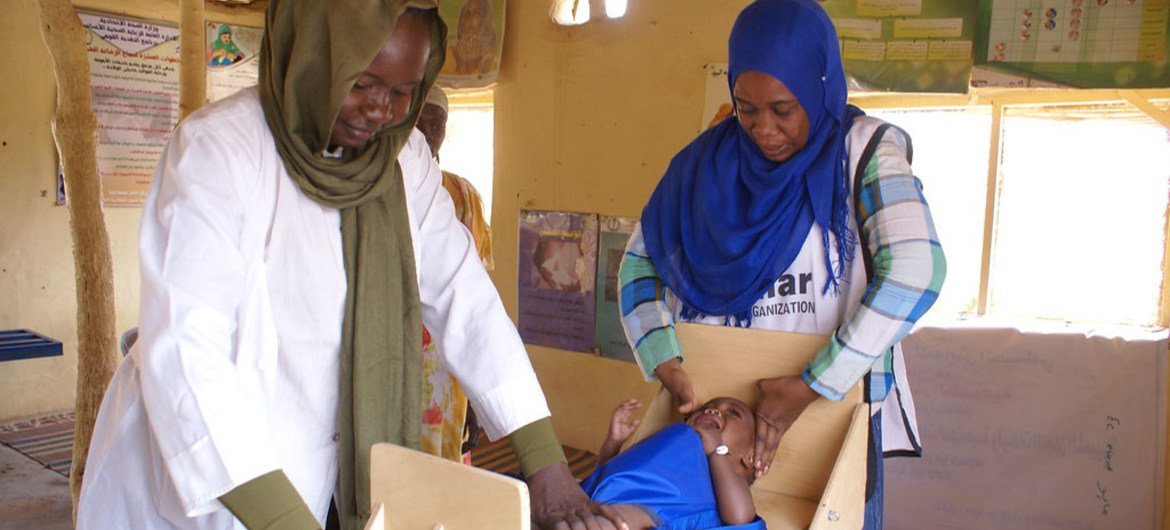 موظفون صحيون يقيسون طول طفل في مركز المنار الصحي في مايو، جنوب الخرطوم، السودان.