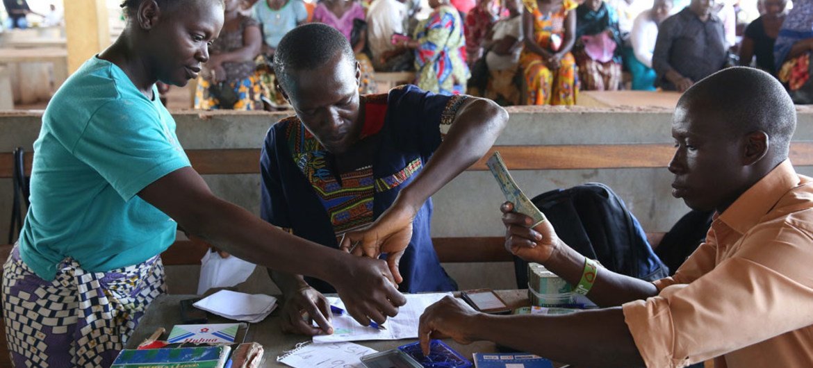 Making cash transfer payments to women in Freetown, Sierra Leone.