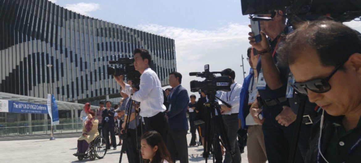 Media gather at the Gyeongju Hwabaek International Convention Center for a flag raising ceremony prior to the 66th DPI/NGO Conference. 29 May 2016.