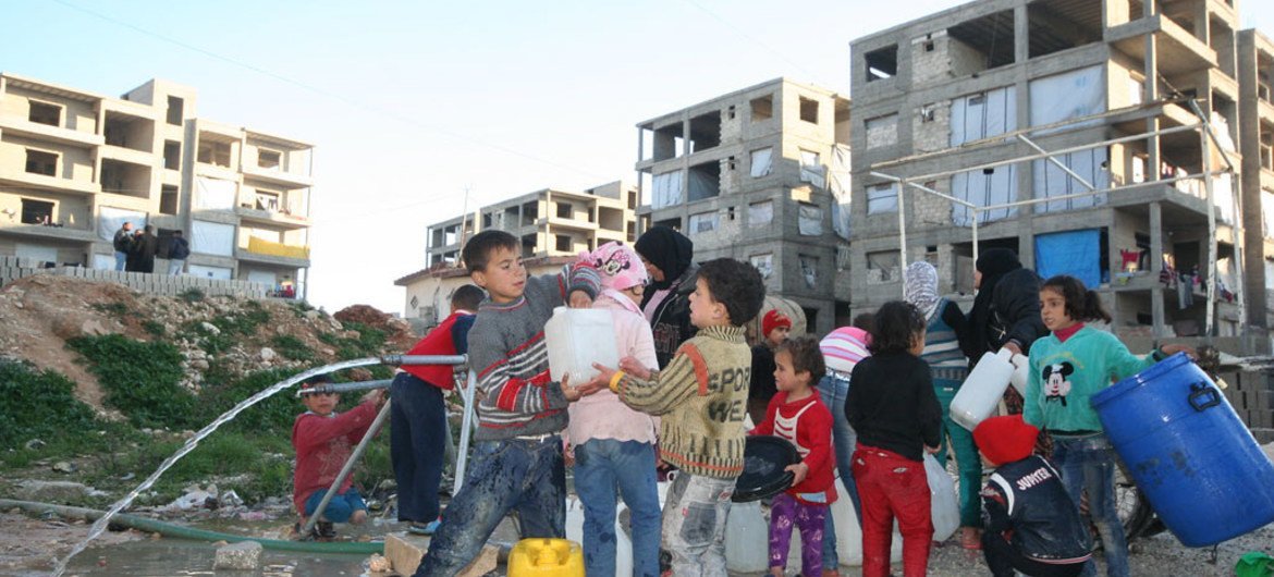 Children collect water at the Al-Riad shelter, Aleppo, Syria.