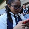 طالبة وغيرها من الفتيات، يتصفحن هواتفهن الذكية بعد انتهاء يومهن الدراسي في مدينة فيساياس الوسطى سيبو، الفلبين. UNICEF/UN014974/Estey