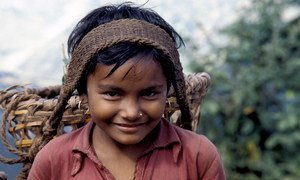 In Nepal, a young girl transports agricultural goods along a 65 km mountain path. When children engage in work that is not appropriate for their age, this is child labour.