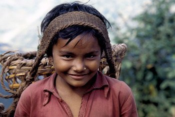 In Nepal, a young girl transports agricultural goods along a 65 km mountain path. When children engage in work that is not appropriate for their age, this is child labour.
