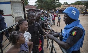 Senegalese peacekeepers from the UN Multidimensional Integrated Stabilization Mission in Mali (MINUSMA) Formed Police Unit (FPU) speak with Malians while they patrol outside Mamadou Konate Stadium during an event to promote peace among the youth.